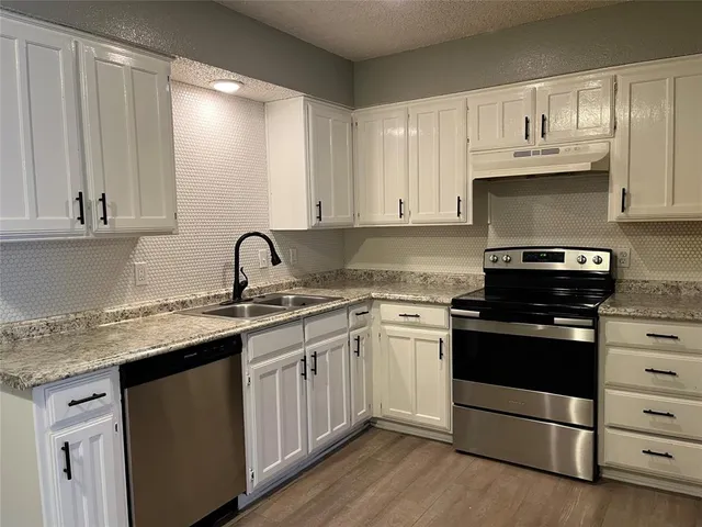 a kitchen with stainless steel appliances granite countertop a sink stove and cabinets