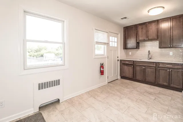 a kitchen with stainless steel appliances granite countertop a stove a sink and a white cabinets