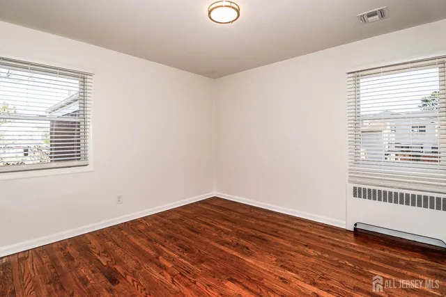 a view of a room with wooden floor and a window