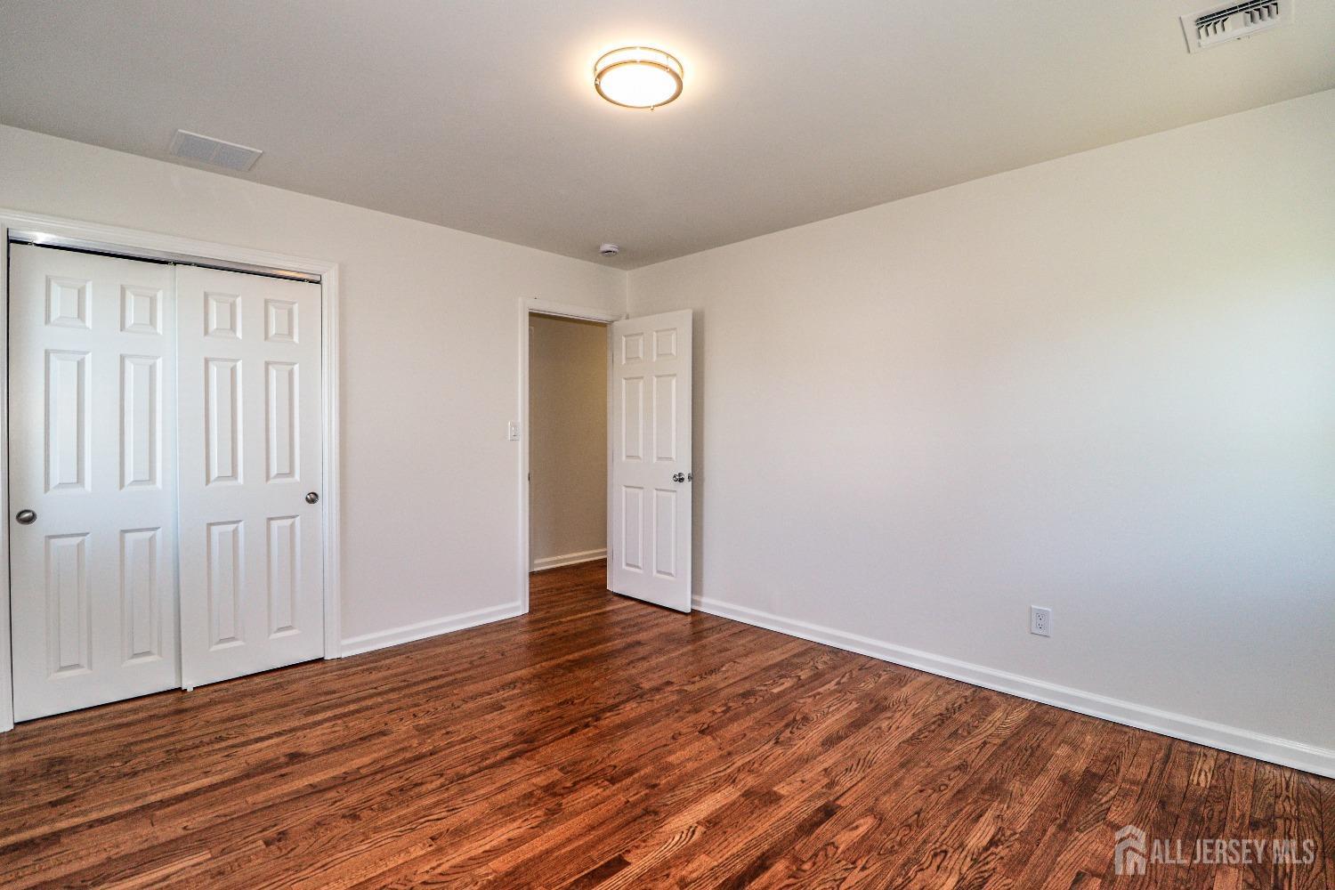 298 Central Avenue, Unit 4A Edison, NJ 08817 - Photo 10 of 12 a view of an empty room with wooden floor