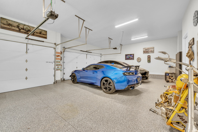 6105 Bunda Way St. George, UT 84790 - Photo 45 of 49 Spacious garage featuring a durable epoxy floor, white walls, and bright overhead lighting