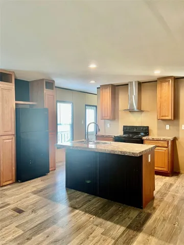 a kitchen with granite countertop a sink cabinets and wooden floor