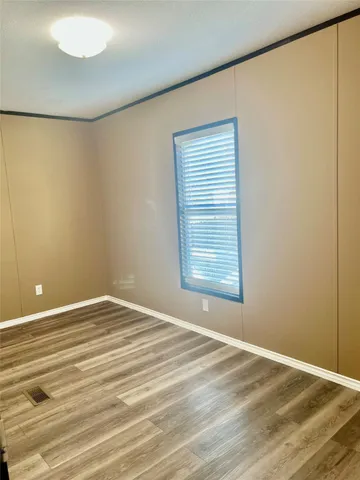 a view of a room with a wooden floor and a window