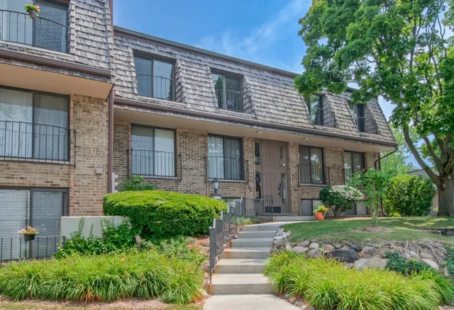 a front view of a house with yard and green space