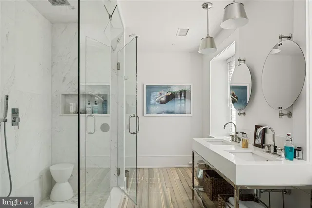 a bathroom with a sink a toilet and shower