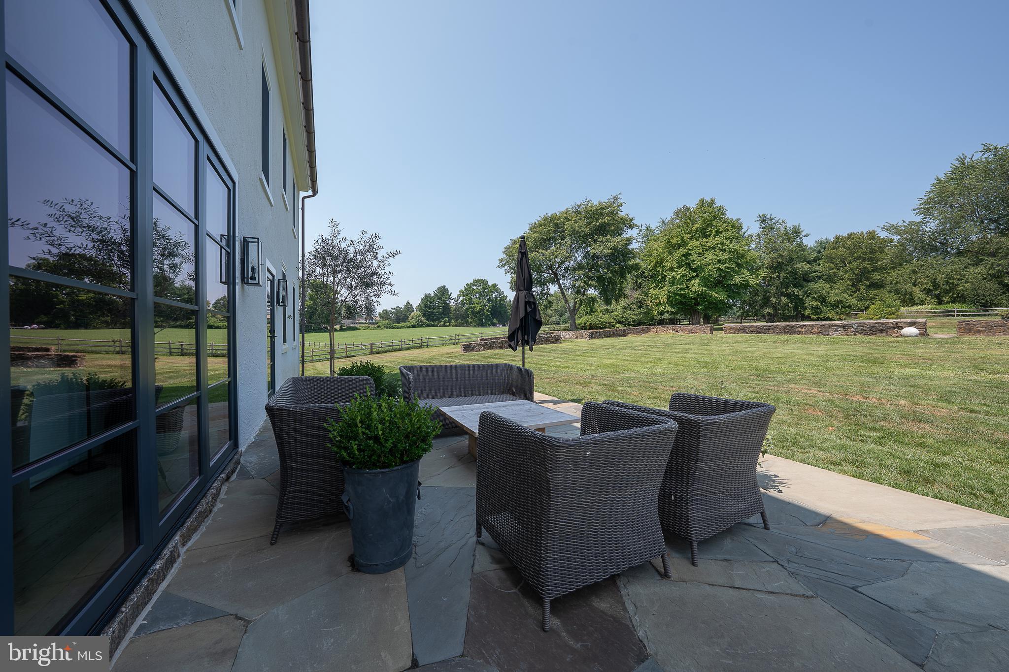 864 Grubbs Mill Road Newtown Square, PA 19073 - Photo 28 of 50 a view of a patio with lawn chairs next to a yard