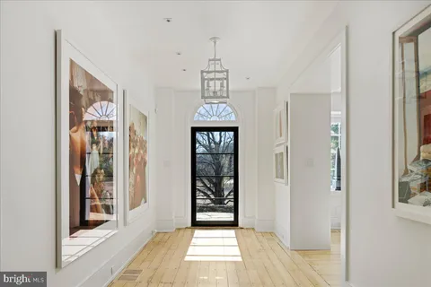 a view of a hallway with wooden floor and a dining room