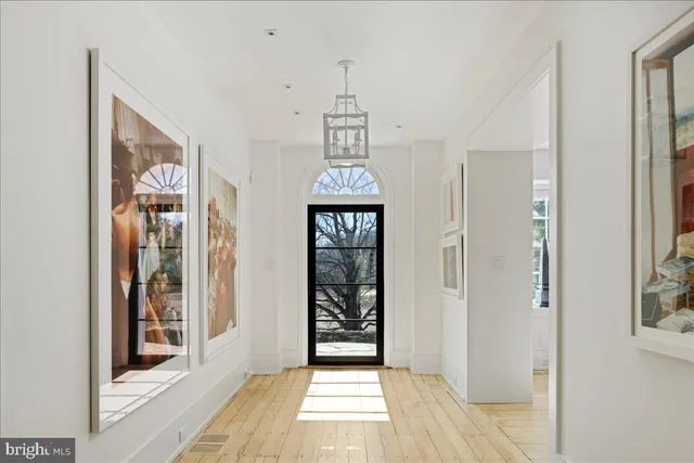 a view of a hallway with wooden floor and a dining room