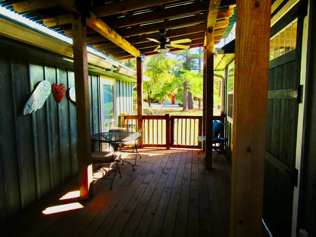 a view of a porch with wooden floor and furniture