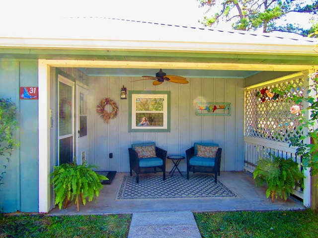 a view of a chairs and table in patio with potted plants