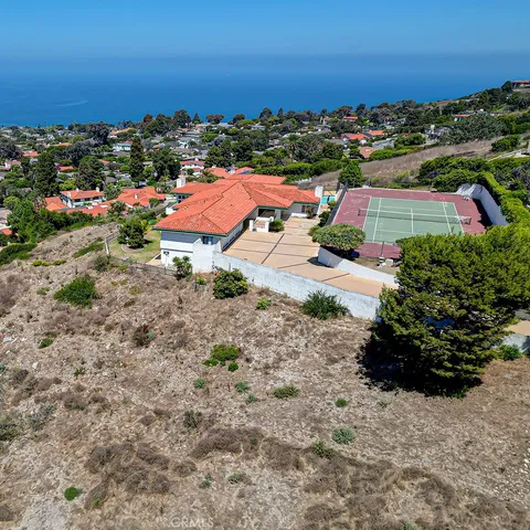 a view of a city with lots of residential buildings ocean and mountain view in back