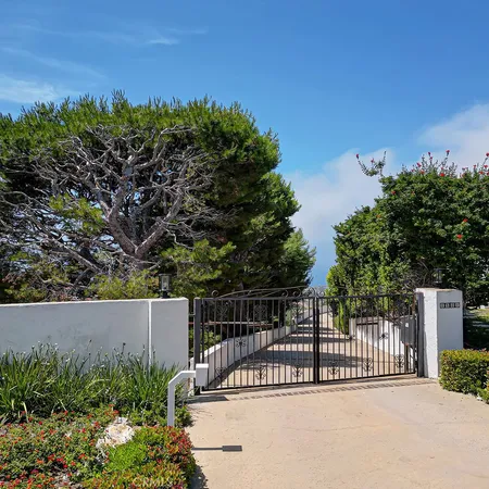 a view of a fence and trees in the background