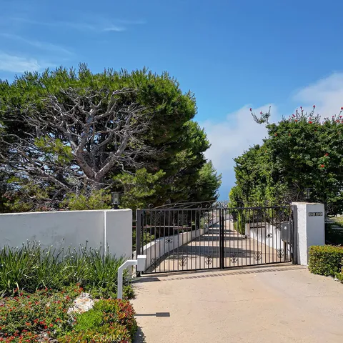 a view of a fence and trees in the background