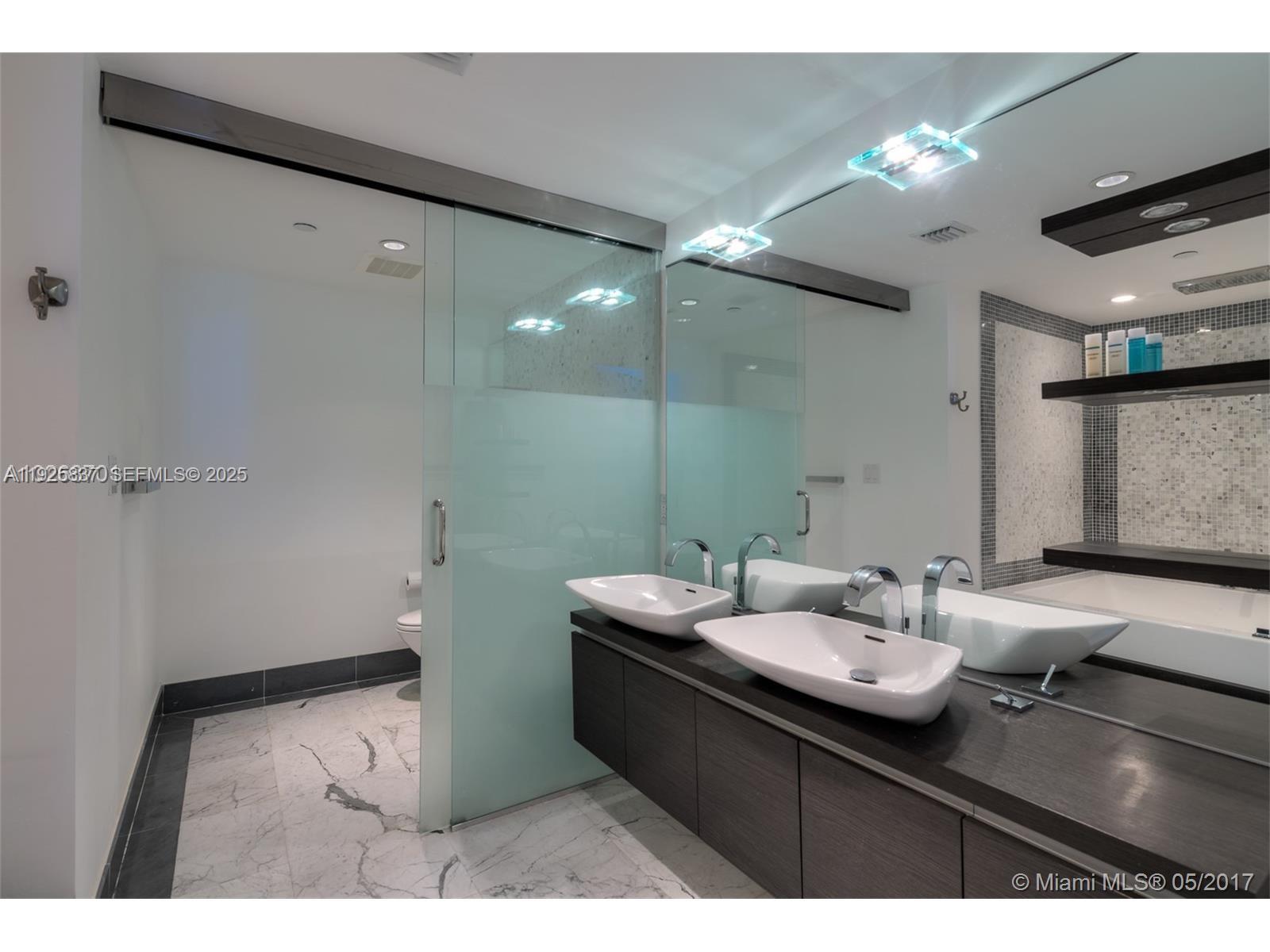 200 Biscayne Blvd Way, Unit 4309 Miami, FL 33131 - Photo 6 of 10 a bathroom with a sink and a mirror