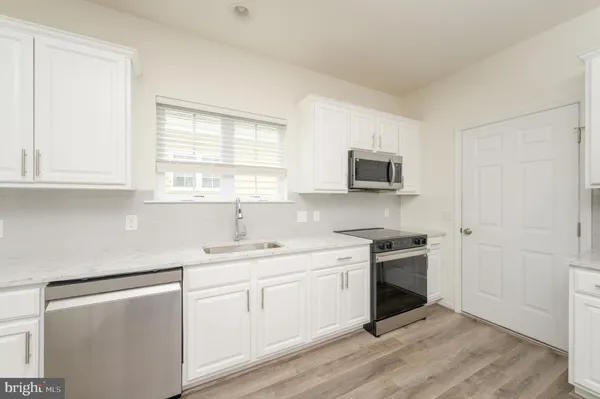 a view with cabinets stainless steel appliances and a window