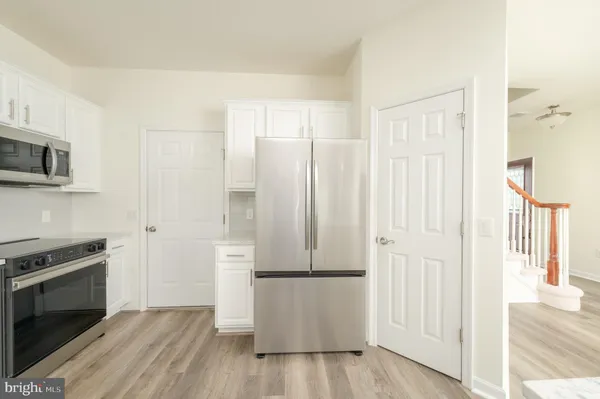 a view of a kitchen with wooden floor and electronic appliances