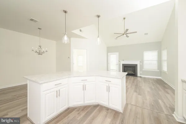 a view of a kitchen with a sink dishwasher a fireplace with wooden floor
