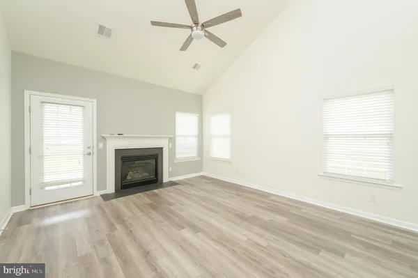 an empty room with windows and fireplace