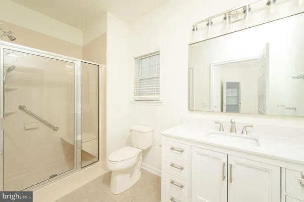 a bathroom with a toilet sink vanity and shower