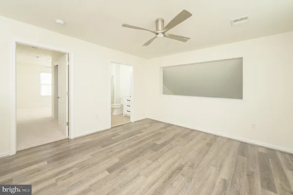 an empty room with a window and a ceiling fan