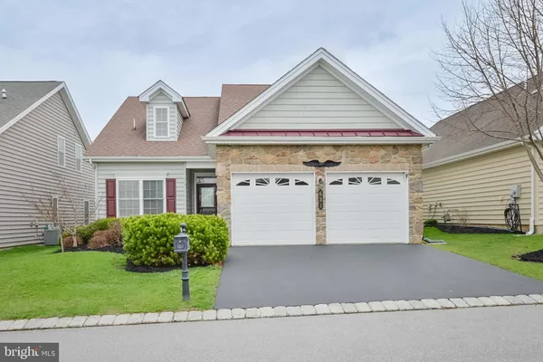a view of a white house with a small yard and plants