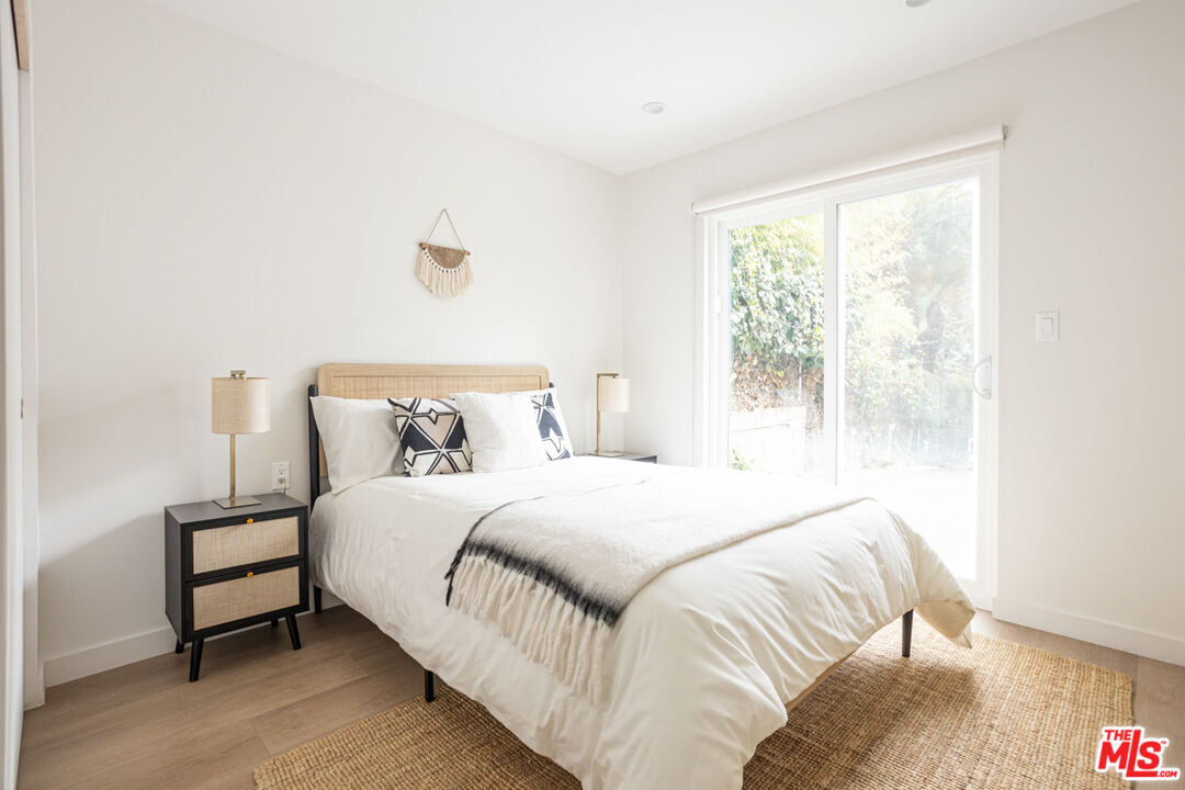 1948 1/2 Preston Avenue Los Angeles, CA 90026 - Photo 6 of 10 a bedroom with a bed lamp and a large window