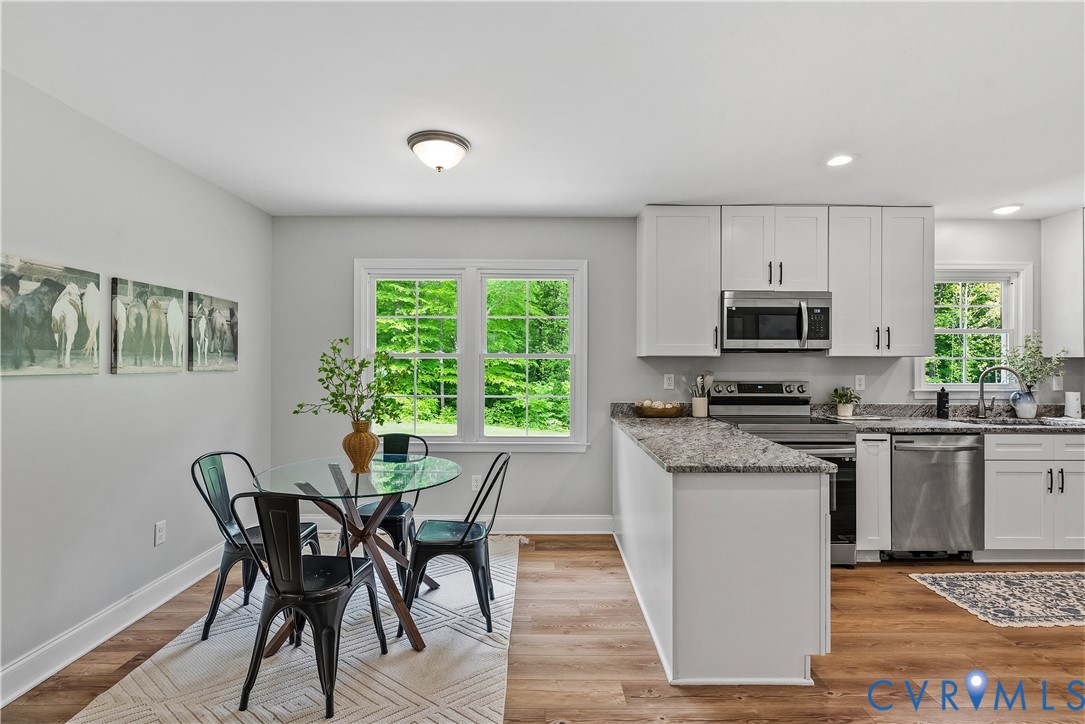 81 Rock Creek Road Cumberland, VA 23040 - Photo 12 of 45 a kitchen with kitchen island granite countertop wooden floors and white appliances