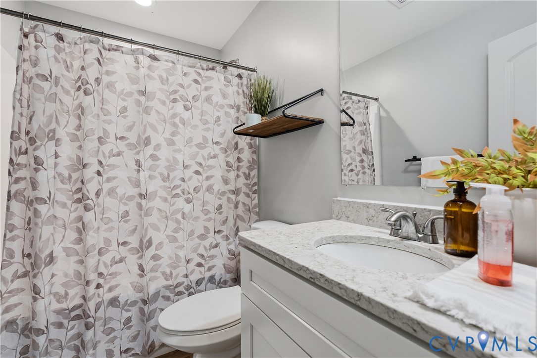 81 Rock Creek Road Cumberland, VA 23040 - Photo 23 of 45 a bathroom with a granite countertop sink a toilet and shower curtain