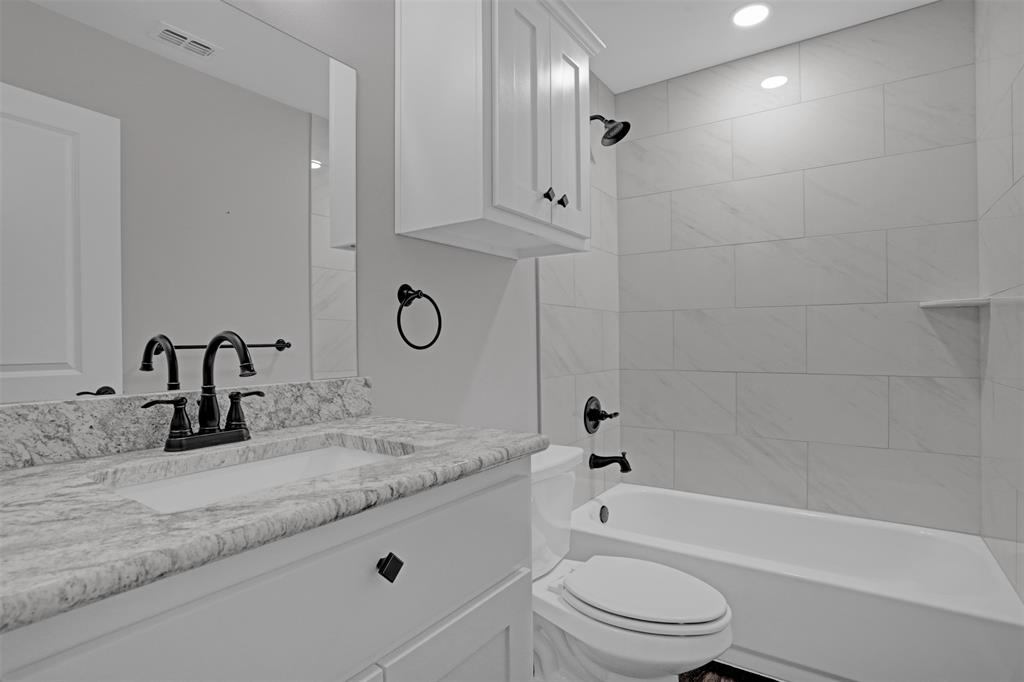 399 South Main Street Blue Ridge, TX 75424 - Photo 18 of 25 a bathroom with a granite countertop sink a toilet and bathtub