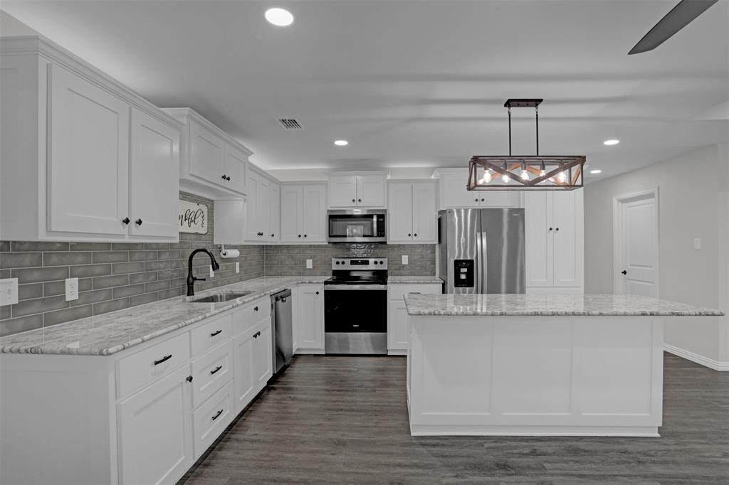 399 South Main Street Blue Ridge, TX 75424 - Photo 7 of 25 a large kitchen with stainless steel appliances granite countertop a stove and cabinets