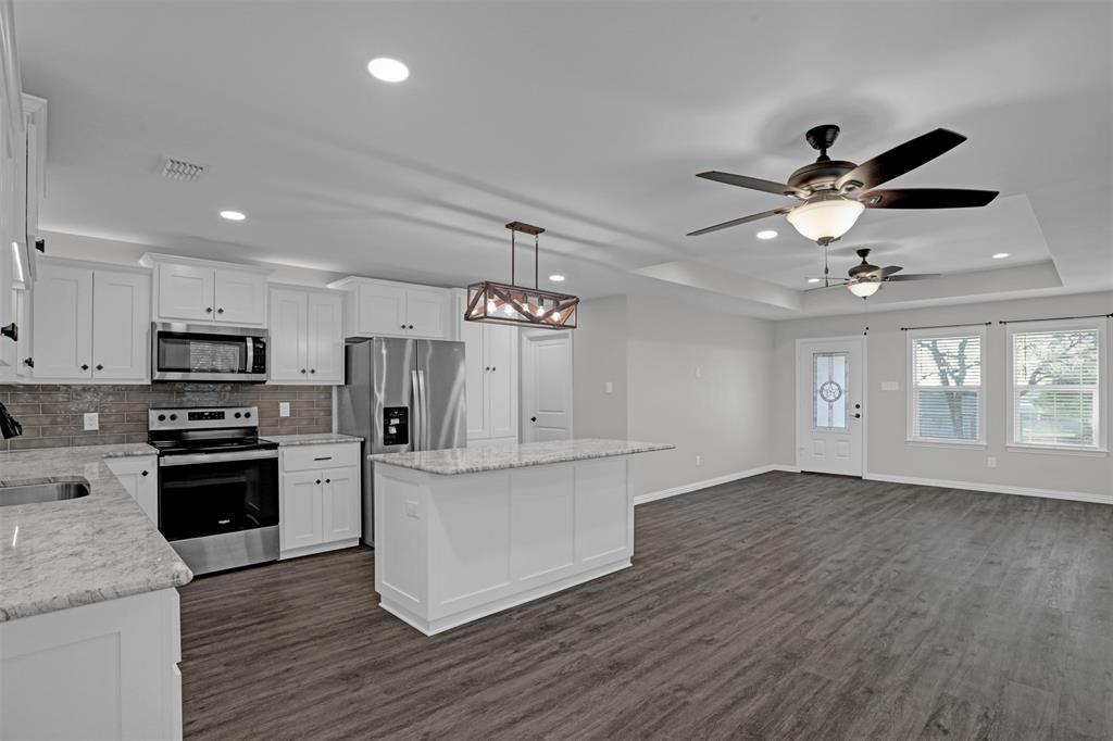 399 South Main Street Blue Ridge, TX 75424 - Photo 10 of 25 a kitchen with stainless steel appliances granite countertop a refrigerator a stove a sink dishwasher and a stove with wooden floor
