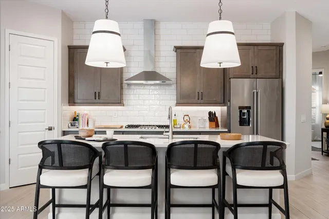 a kitchen with granite countertop a sink cabinets and chairs in it