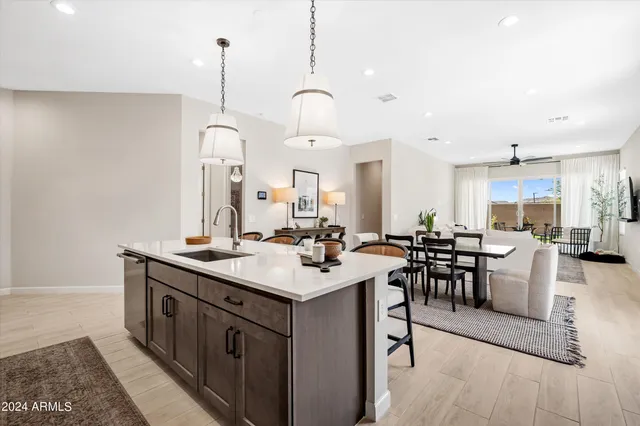 a room with lots of wooden furniture a sink a dining table and chairs