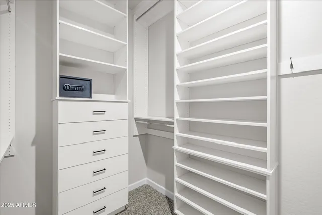 a view of walk in closet with clothes