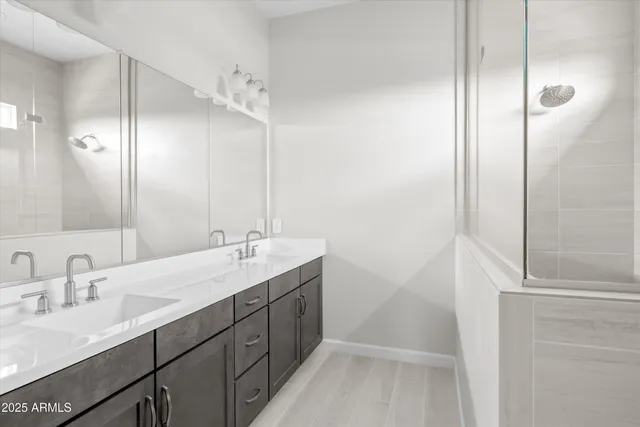 a bathroom with a double vanity sink mirror and shower