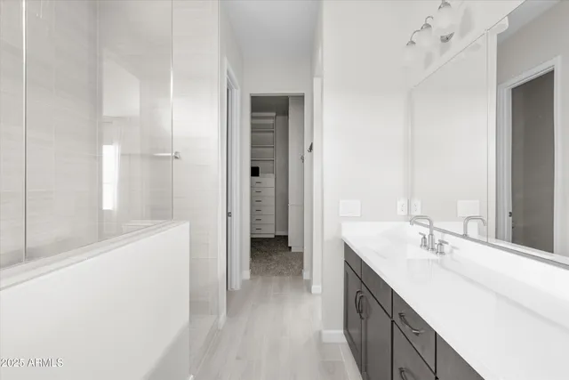 a bathroom with a double vanity sink a mirror and a bathtub