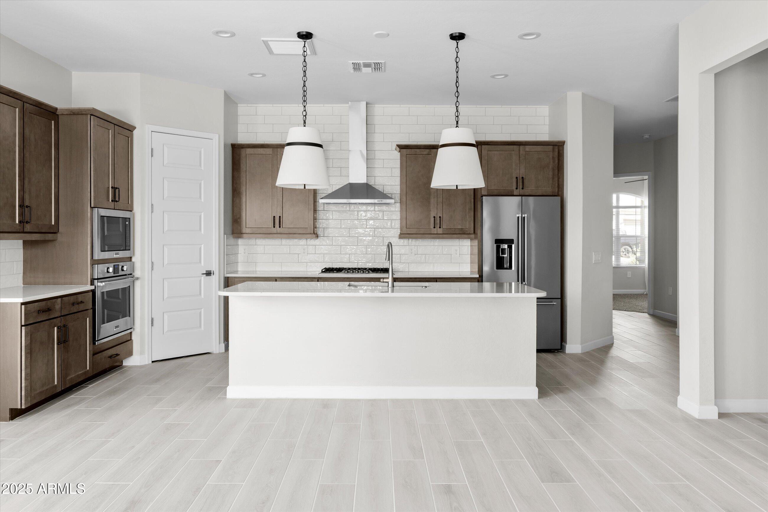 21425 North 59th Street Phoenix, AZ 85054 - Photo 4 of 47 a large kitchen with stainless steel appliances granite countertop a refrigerator a oven and a wooden floors