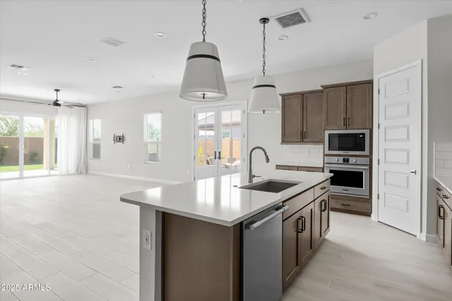 a kitchen with stainless steel appliances granite countertop a sink a stove and a refrigerator