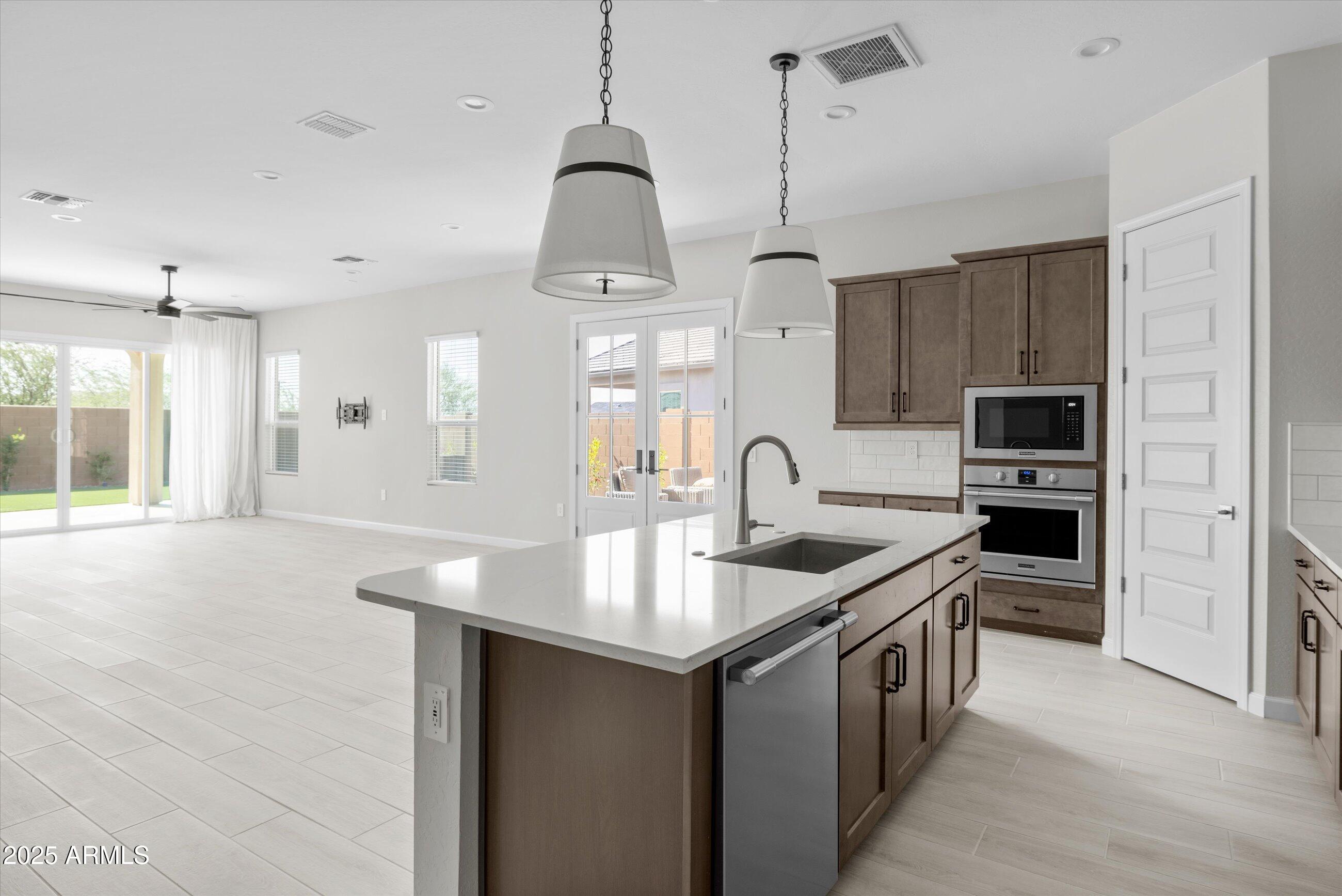 21425 North 59th Street Phoenix, AZ 85054 - Photo 6 of 47 a kitchen with stainless steel appliances granite countertop a sink a stove and a refrigerator
