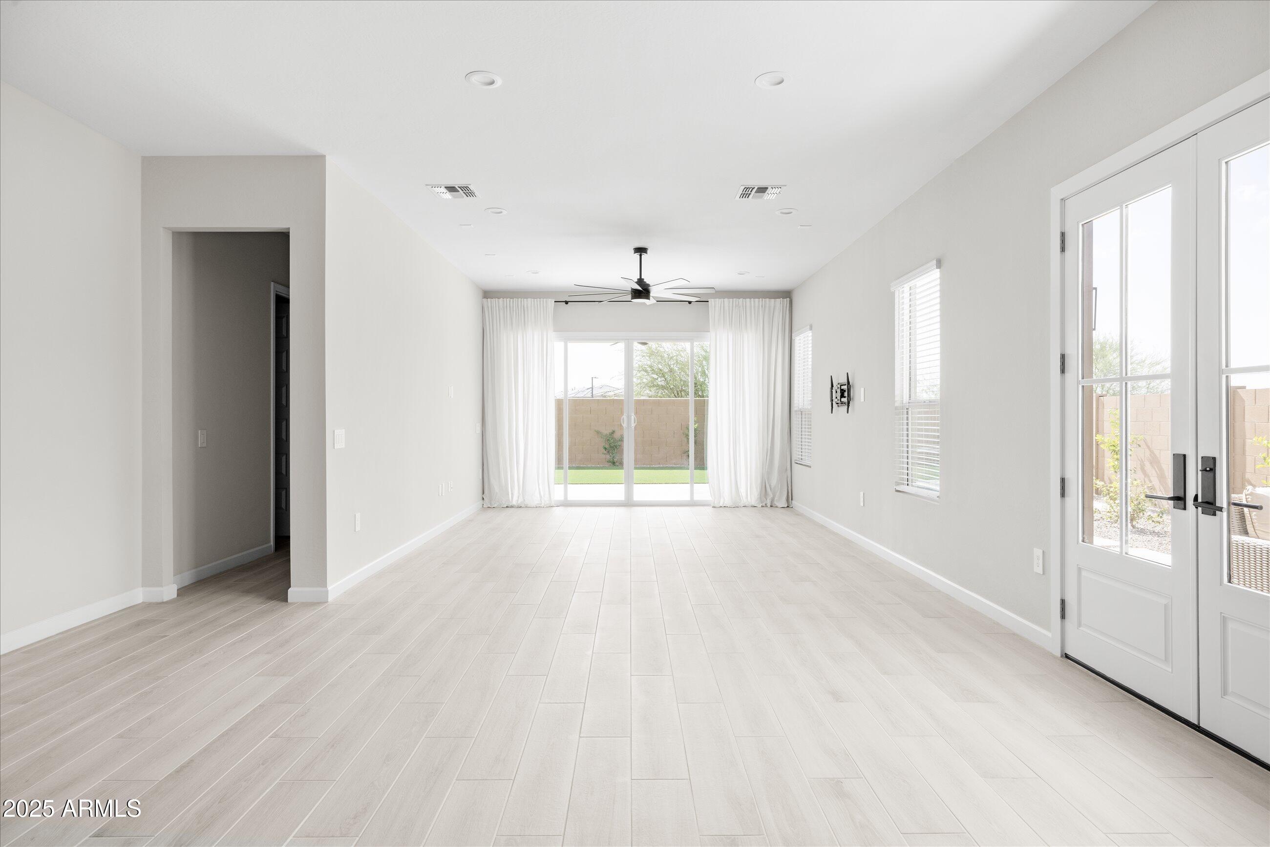 21425 North 59th Street Phoenix, AZ 85054 - Photo 9 of 47 a view of an empty room with a window and wooden floor