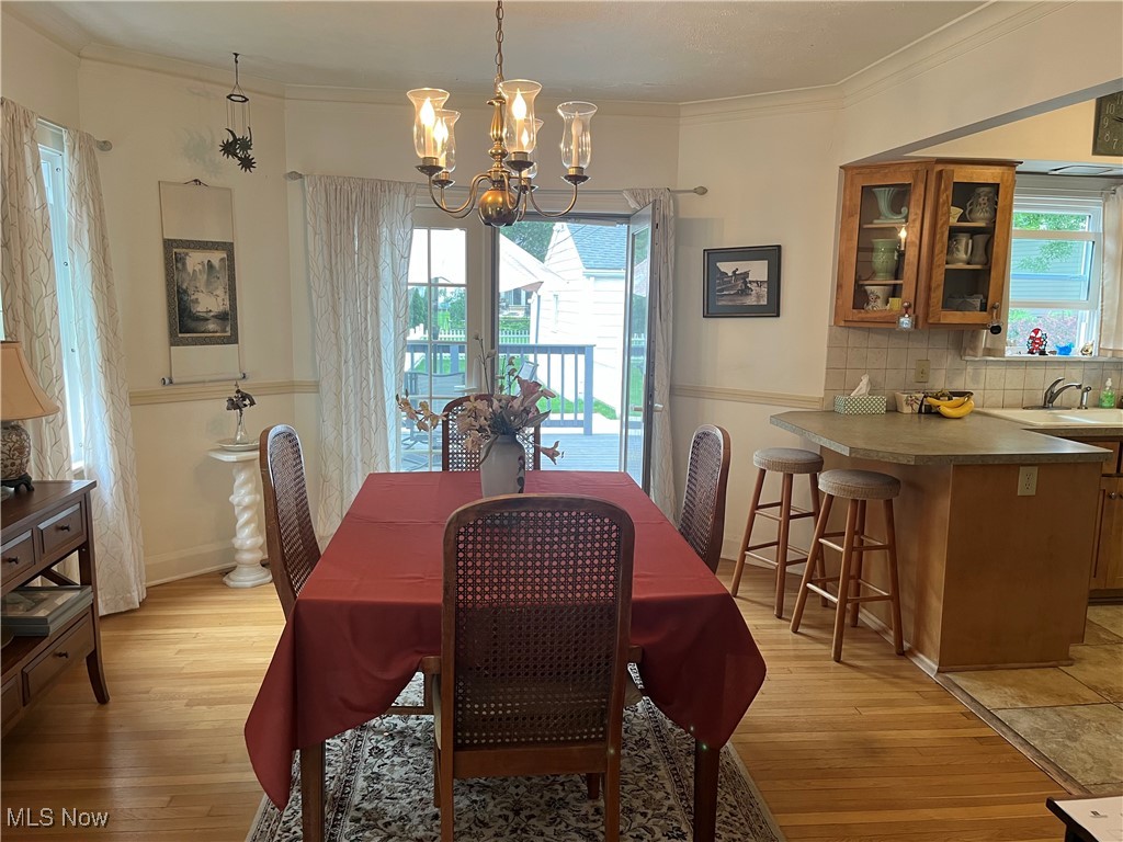 134 Ridgewood Drive Youngstown, OH 44512 - Photo 6 of 29 Dining space with light wood finished floors, a chandelier, and ornamental molding