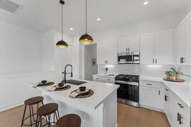 a kitchen with a sink a stove and chairs