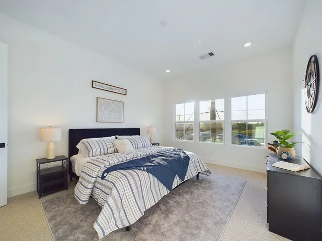 a spacious bedroom with a bed and a painting on the wall
