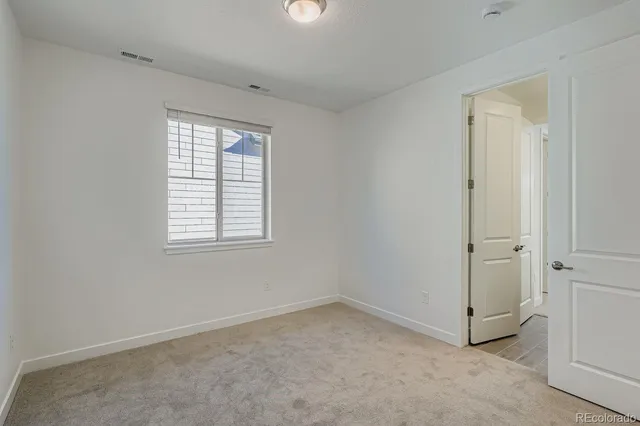 an empty room with windows and closet