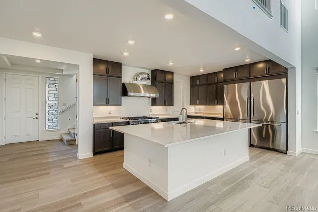 a large white kitchen with a stove a sink and a refrigerator