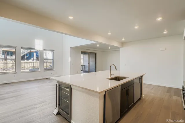 a kitchen with a sink and wooden floor
