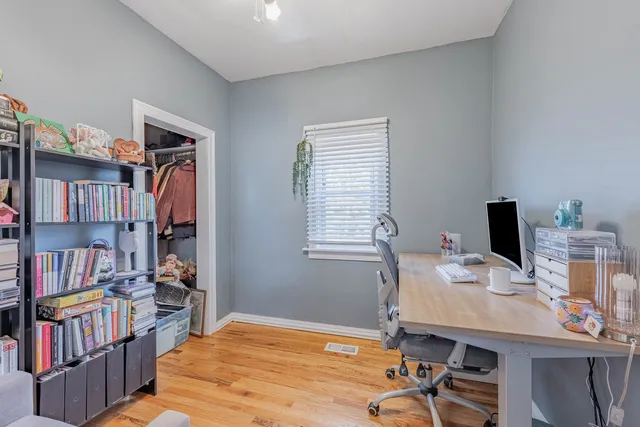 a view of a workspace with furniture and a book shelf