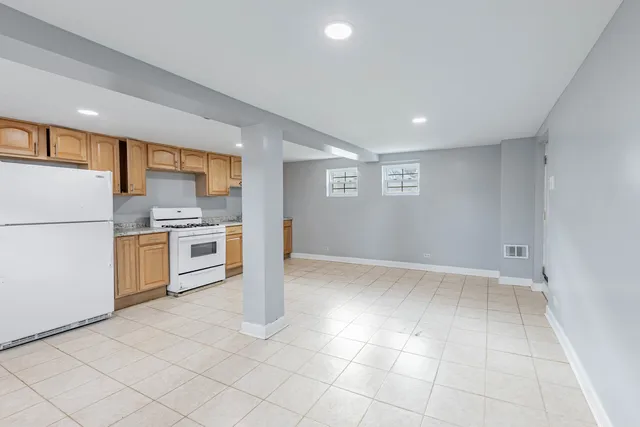 a kitchen with stainless steel appliances granite countertop a refrigerator a stove and a sink