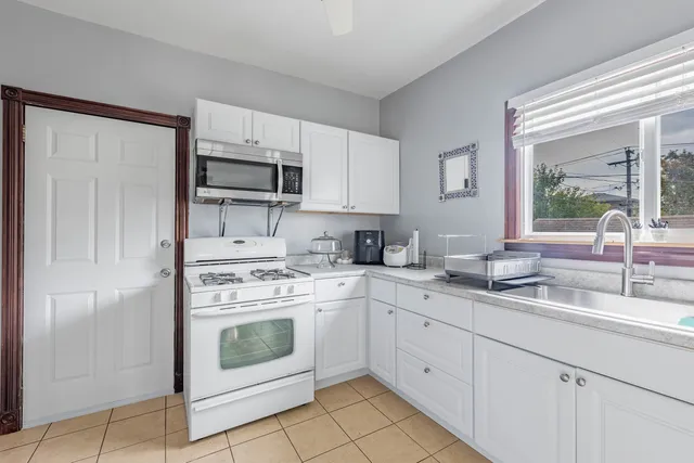 a kitchen with white cabinets and white appliances