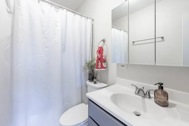 a bathroom with a sink vanity mirror and toilet